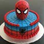 A red and blue Spiderman-themed cake with web patterns and a fondant Spiderman topper.